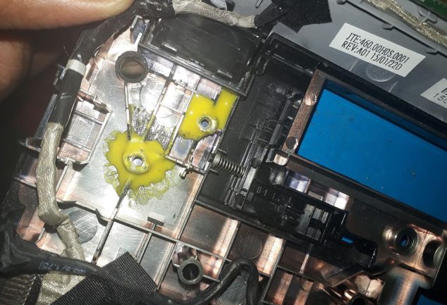 A laptop being repaired on a workbench